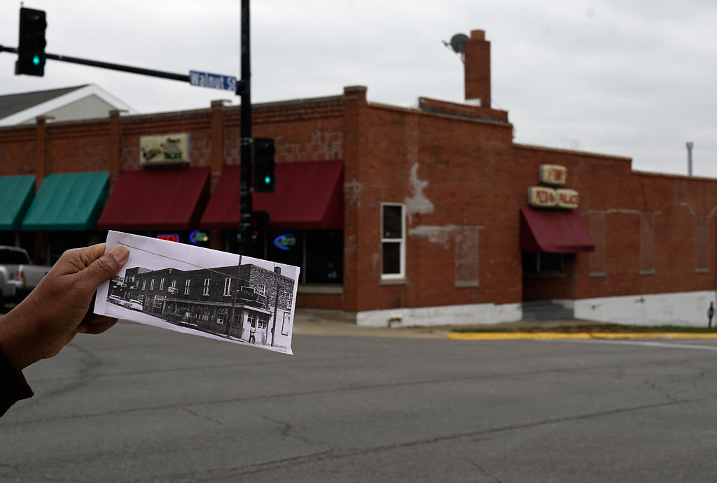 Ed Tibbs compares a photo of his building, located at 5th and Walnut, to the building today